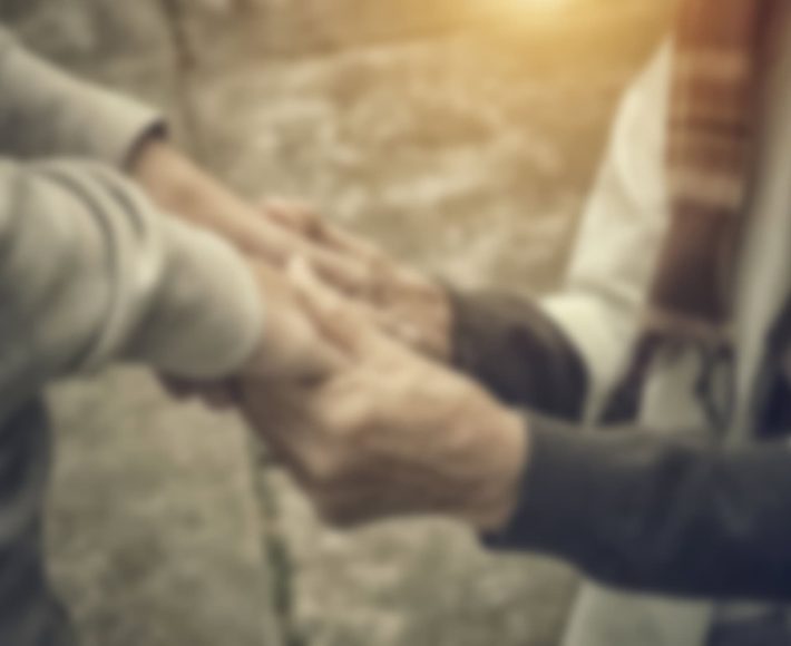 Supportive hands holding each other during a funeral service.